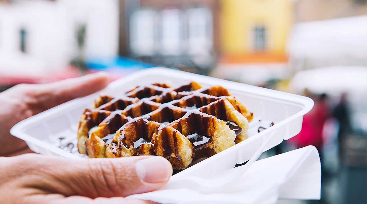 A Belgian waffle covered in chocolate sauce